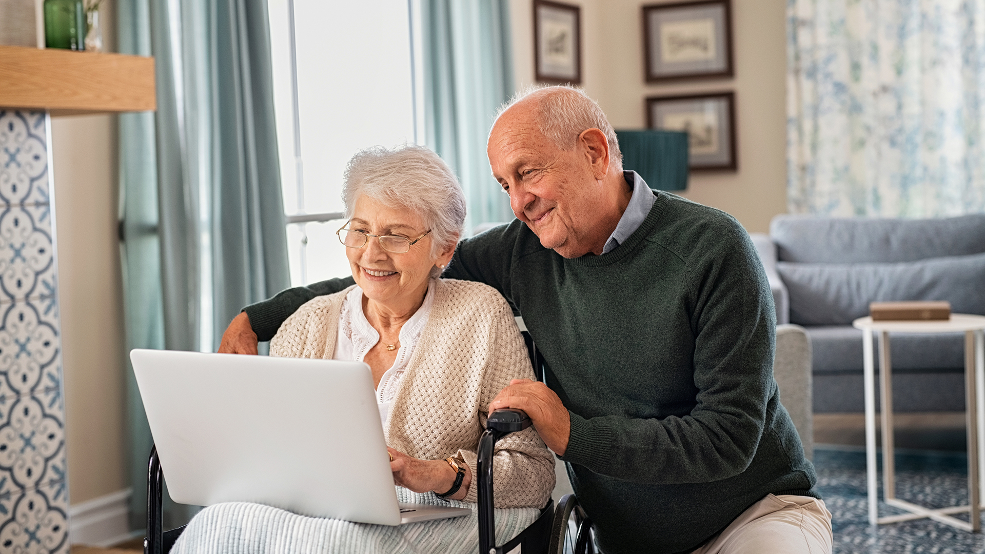 senior couple looking at a laptop together in the living room