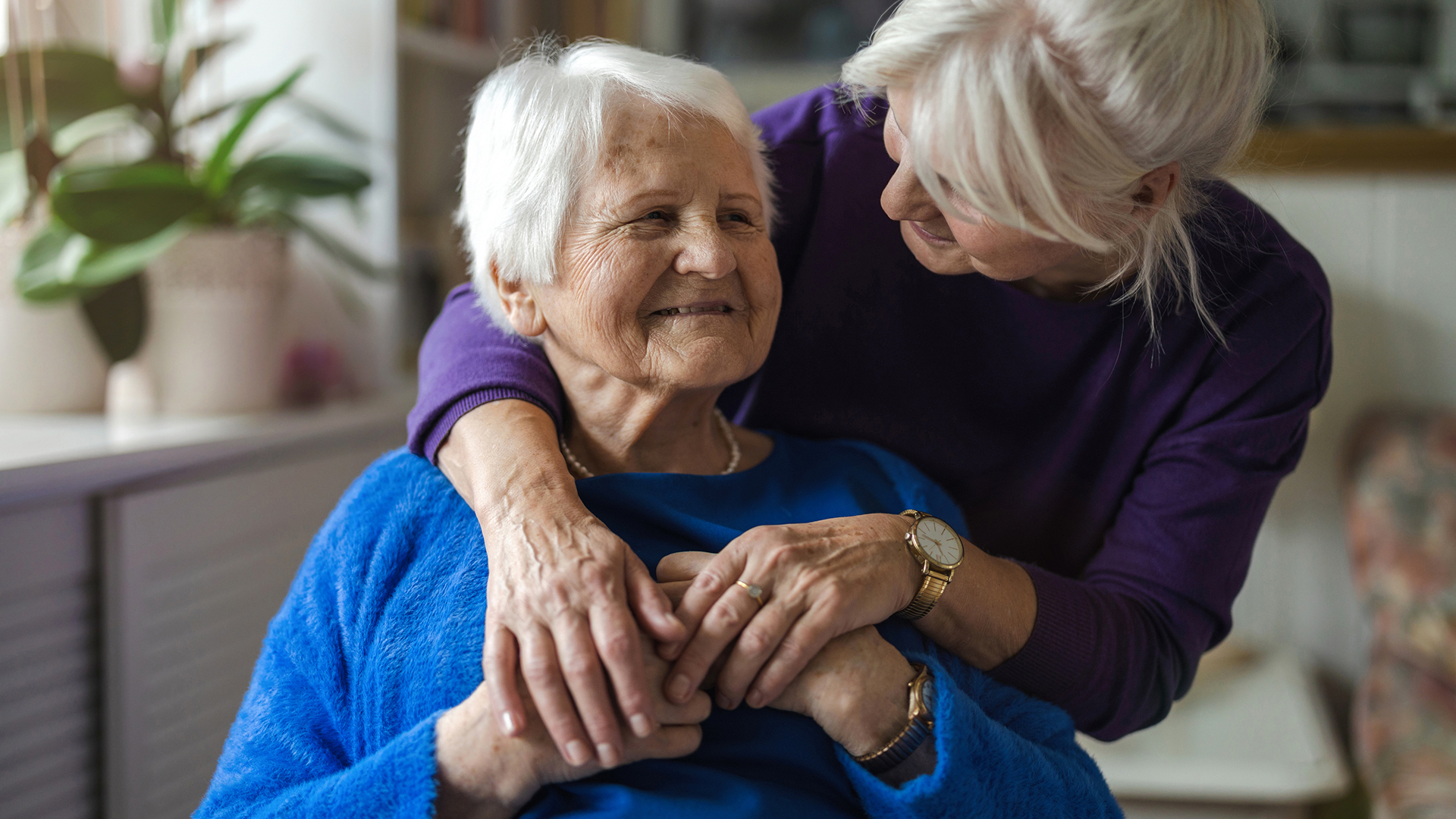 Woman hugging her elderly mother in memory care